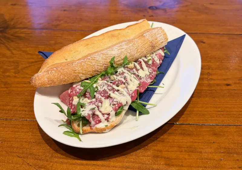 Een belegd stokbroodje met carpaccio en rucola