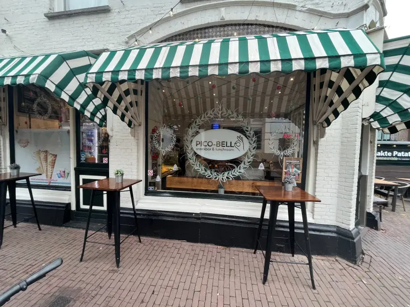 De pui van Pico-Bello onder de groen-witte luifel, met statafels op de stoep